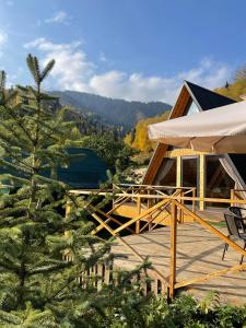 una casa con terraza y un árbol en Eywa House en Kamenskoye Plato