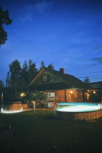 une maison avec une piscine en face de celle-ci la nuit dans l'établissement Zacisze Pod Lipą, à Andrychów