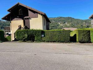 a house with green hedges in front of it at Cocon des chaumes in La Bresse