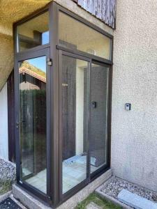 a glass door on the side of a building at Cocon des chaumes in La Bresse