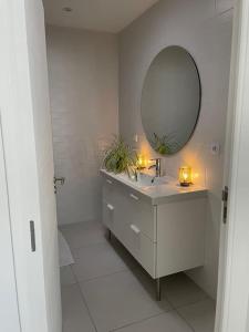 a bathroom with a sink and a mirror at Agréable maison individuelle proche Bordeaux in Ambarès-et-Lagrave