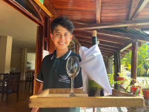 a young man standing next to a table with a wine glass at La Casa del Marqués Hotel in El Chaco