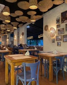 um restaurante com mesas de madeira e cadeiras azuis em George V Alto de Pinheiros Suite 208 Luxo - Adm Privada - Café da manhã em São Paulo