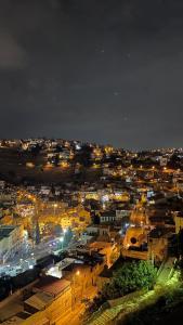 una ciudad iluminada por la noche con luces de la calle en Saraya locanda en Al Salt