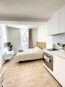 eine Küche und ein Schlafzimmer mit einem Bett in einem Zimmer in der Unterkunft Le Nacre 24 - Bourg-de-Péage in Bourg-de-Péage