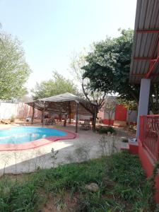 a pool with a pavilion and a table and chairs at ANSTA SELF CATERING Home in Outjo