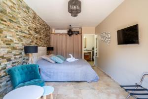 een slaapkamer met een bed en een blauwe stoel bij Villa Golf les Cigales in Mouans-Sartoux