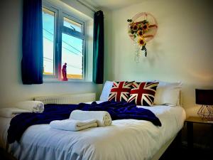 a bed with towels on it in a room with a window at 4 Bedroom House -Sleeps 10- Big Savings On Long Stays! in Canterbury