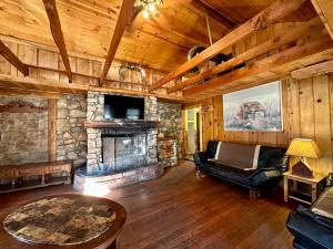 sala de estar con sofá y chimenea de piedra en Boulder Bay Cottages, en Big Bear Lake
