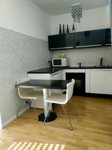 une cuisine avec une table et une chaise. dans l'établissement Appartamento con terrazzo privato Milano San Raffaele Linea verde, à Vimodrone