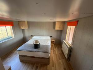 a small room with a bed and two windows at Casa rural LYA in Fuensaldaña