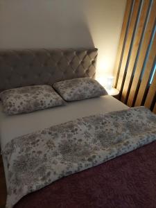 ein Bett mit zwei Kissen darüber in der Unterkunft Apartman ENEM in Mostar