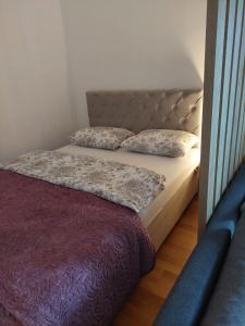 ein Bett mit zwei Kissen auf einem Zimmer in der Unterkunft Apartman ENEM in Mostar