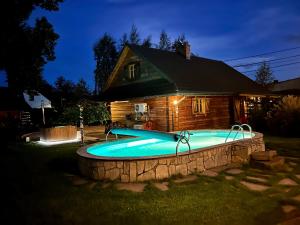 a swimming pool in front of a house at night at Gniazdko Pod Lipą in Andrychów