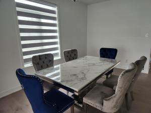 a dining room with a marble table and chairs at Good Fortune Residence, Ottawa in Ottawa