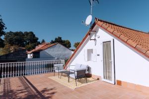 a white house with two chairs on a patio at La Finca de Aurora in San Rafael