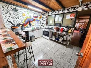 a large kitchen with a map on the wall at Hostal Pampaloja Antof in Antofagasta