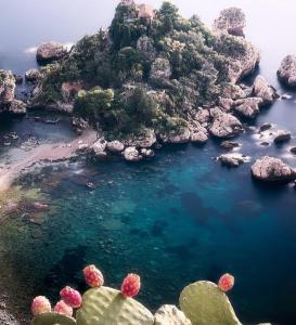 - une vue aérienne sur une plage de rochers et d'eau bleue dans l'établissement Amelia's Home tra Etna e Taormina with pool, à Riposto