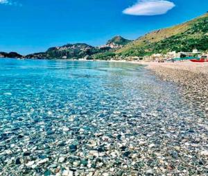 - une plage avec des rochers et l'eau dans l'établissement Perla de Mar a 20m dalla spiaggia, à Letojanni