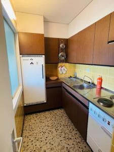 een keuken met een witte koelkast en een wastafel bij Appartement 2 pièces (55m2) , central et garage in Crans-Montana