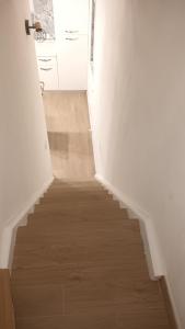 a staircase with a wooden floor and white walls at Perla de Mar a 20m dalla spiaggia in Letojanni +21 photos