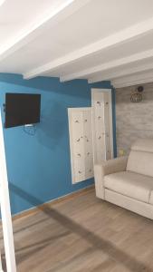 a living room with a couch and a flat screen tv at Perla de Mar a 20m dalla spiaggia in Letojanni