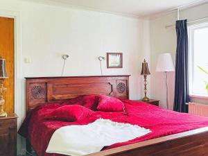 a bedroom with a large red bed with red pillows at Holiday home MARIESTAD XI in Mariestad