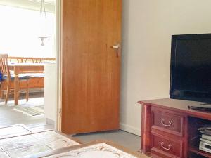 a living room with a television and a wooden door at Holiday home MARIESTAD XI in Mariestad
