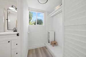 a white bathroom with a sink and a window at Magic Mountain 4 Bedroom 3 Bath Escape Modern Home in Santa Clarita +30 photos