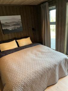 um quarto com uma cama branca e uma janela em Polaren by Norgesbooking - cabin with amazing view em Notodden