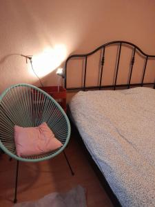 een slaapkamer met een bed en een stoel naast een bed bij Achter de Vesting in Bourtange
