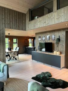 uma sala de estar com uma televisão, um sofá e uma mesa em Polaren by Norgesbooking - cabin with amazing view em Notodden