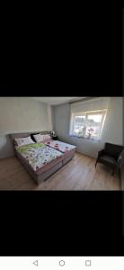 een slaapkamer met een bed en een stoel en 2 ramen bij Haus mit schöner Aussicht WG in Münsingen