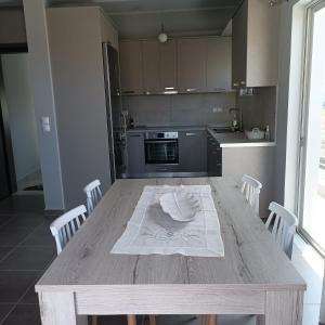 una cucina con tavolo in legno e asciugamani bianchi di Anemos House a Anemokhórion