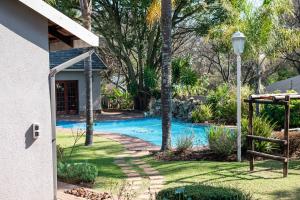 a house with a swimming pool in a yard at Tranquil cottage in Sandton