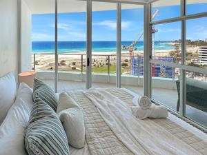 a bedroom with a bed with a view of the beach at Kirra Penthouse with Private Spa in Gold Coast