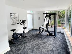 a gym with treadmills and exercise bikes in a room at Kirra Penthouse with Private Spa in Gold Coast
