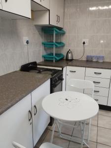 a kitchen with a table and a white table and chairs at Ekhaya Sun Villa in Richards Bay