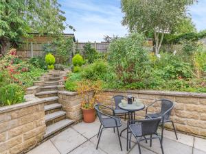a patio with chairs and a table in a garden at Cherry Tree Corner in Ashbourne
