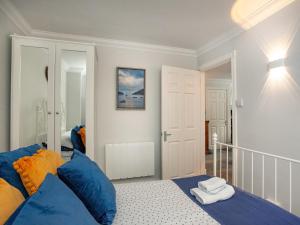 a bedroom with blue and orange pillows on a bed at Captains Lockyer in Kingswear