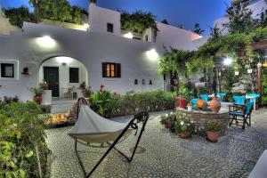 a patio with a table and chairs in front of a building at Eleni Rooms in Parikia