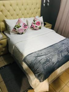 a bed with two pillows on top of it at Ekhaya Sun Villa in Richards Bay
