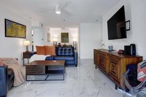 een woonkamer met een bank en een tv bij Modern Plaza Villas Oasis in Palm Springs
