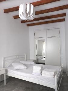 a white bedroom with a bed and a mirror at Stella' s house Castle of Chora Naxos in Naxos Chora