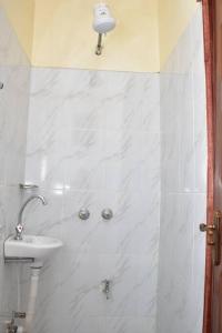 een witte badkamer met een wastafel en een douche bij Marie's 1br near Sarovawoodlands in Nakuru