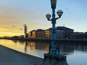 a light pole next to a body of water at Perfectly located City Centre apartments in Exeter