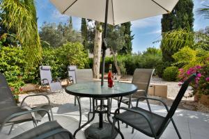 a table and chairs with an umbrella on a patio at Casa Del Sol Townhouse in Iris Village Paphos in Paphos City