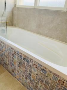 Maison Evasion Voyage parking et jardin by Art de Voyager في إتريتا: حمام مع حوض استحمام مع نافذة +17 صورة