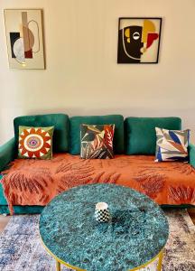 - un salon avec un canapé vert et une table dans l'établissement Maison Evasion Voyage parking et jardin by Art de Voyager, à Étretat