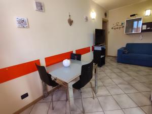 a table and chairs in a room with a couch at Residenza tra Parma e Fiere in Baganzola